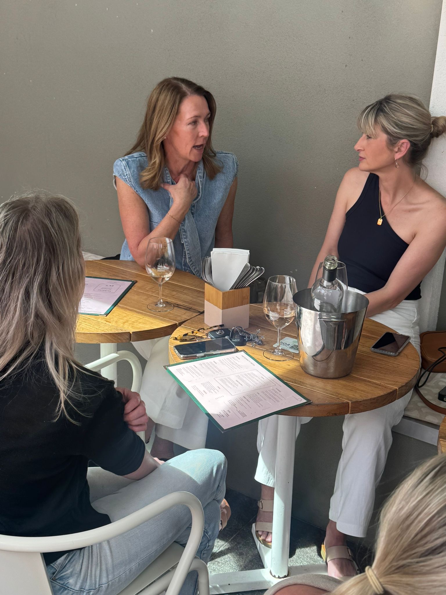 WITH community gathering — women in conversation around a table